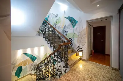 a staircase with a mural of plants on the wall at NATALI Luxury suites PARKING in Belgrade