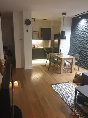 a living room and kitchen with a table and chairs at Apartment Mona in Belgrade