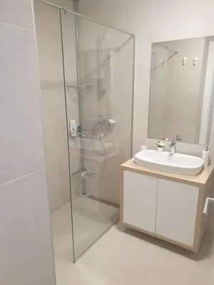 a bathroom with a glass shower and a sink at Apartment Mona in Belgrade