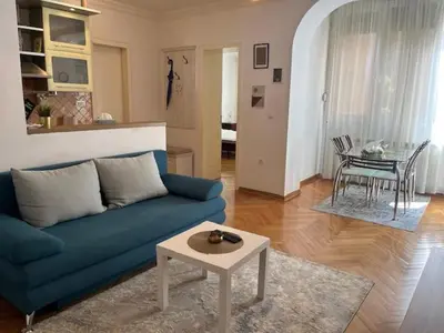 a living room with a blue couch and a table at Apartment Carpe diem in Belgrade in Belgrade