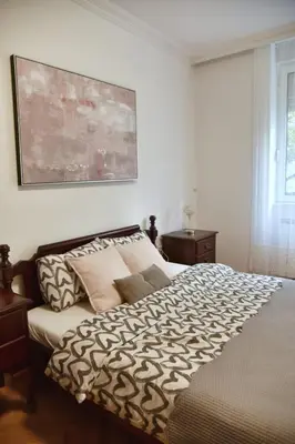 a bedroom with a bed and a painting on the wall at Apartment Carpe diem in Belgrade in Belgrade