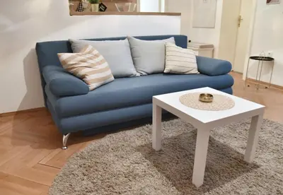a blue couch with a white coffee table in a living room at Apartment Carpe diem in Belgrade in Belgrade