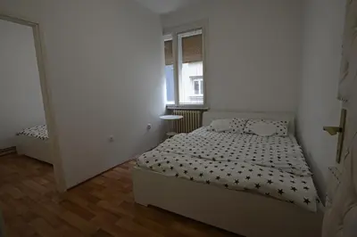 a small bedroom with a bed and a window at Royal MegaKing apartment in Belgrade