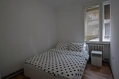 a small bedroom with a bed with polka dot sheets at Royal MegaKing apartment in Belgrade