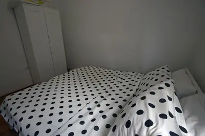 a bed with black and white polka dot sheets at Royal MegaKing apartment in Belgrade