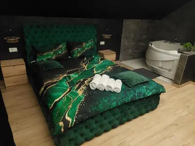 a bedroom with a green bed and a bath tub at Stars lux room in Belgrade