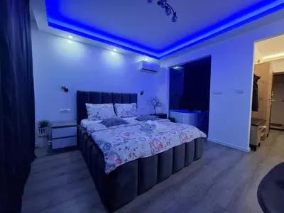a bedroom with a large bed with a blue ceiling at Stars lux room in Belgrade