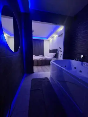 a bathroom with a tub and a bedroom with a bed at Stars lux room in Belgrade