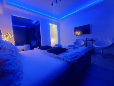 a bedroom with a large bed with blue lighting at Stars lux room in Belgrade