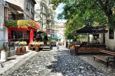 a woman walking down a cobblestone street at Iv Skadarlija in Belgrade