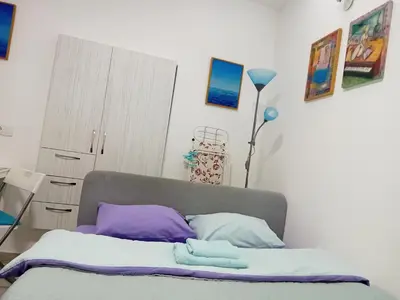a bedroom with a bed with purple and white pillows at Iv Skadarlija in Belgrade