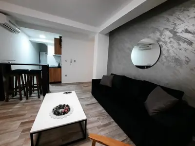 a living room with a black couch and a table at Apartman 57 in Vračar (historical)