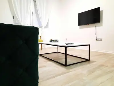 a living room with a coffee table and a tv at Apartman 57 in Vračar (historical)