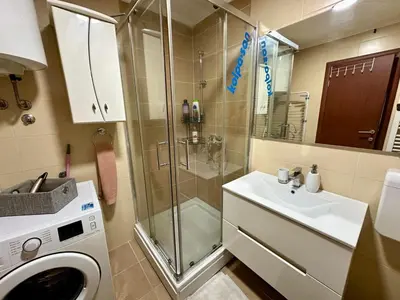 a bathroom with a shower and a sink and a washing machine at Belgrade Apartment 1 in Zvezdara