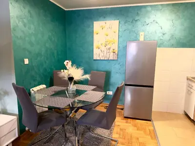 a dining room with a table and a refrigerator at Belgrade Apartment 1 in Zvezdara