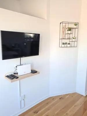 a flat screen tv sitting on a shelf in a room at Jordan Apartment - City Center in Belgrade