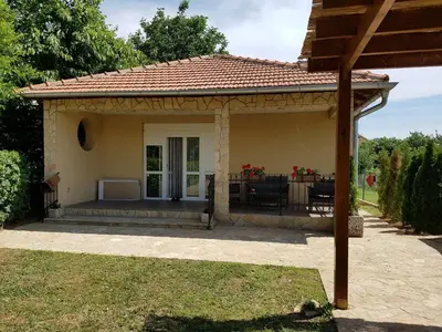 a small house with a patio in a yard at Vikendica Lešić in Čortanovci