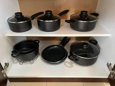 four pots and pans on a shelf in a kitchen at Vikendica Lešić in Čortanovci
