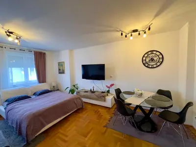a bedroom with a bed and a table and a tv at Belgrade Apartment 2 in Zvezdara