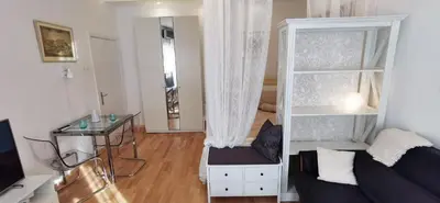 a room with a bed and a desk and a table at Gala City Center Apartman in Belgrade