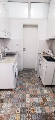 a kitchen with a tiled floor with a sink at Gala City Center Apartman in Belgrade