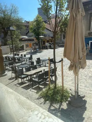 an umbrella and benches and tables and chairs at Traveling Actor Skadarlija in Belgrade