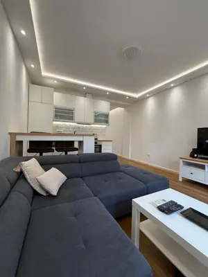 a living room with a blue couch and a kitchen at Apartment, Stari Grad, Belgrade in Belgrade