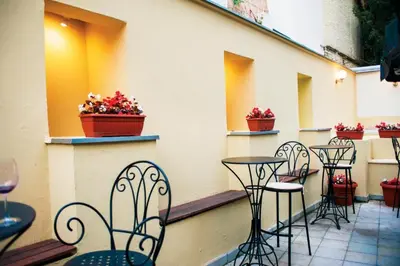 a row of chairs and tables on a patio with flowers at Bulevar Star Apartment in Belgrade