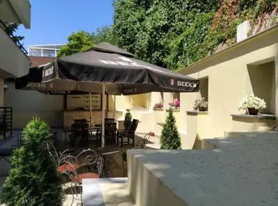 a patio with an umbrella and tables and chairs at Bulevar Star Apartment in Belgrade