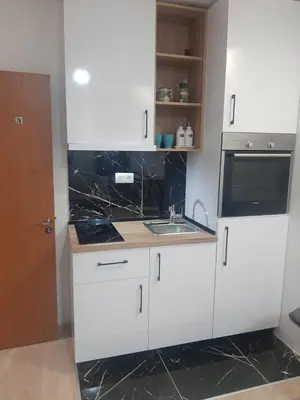 a white kitchen with a sink and a microwave at Bulevar Star Apartment in Belgrade