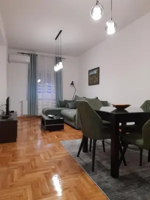 a living room with a table and a couch at Apartman Green wood in Arandjelovac
