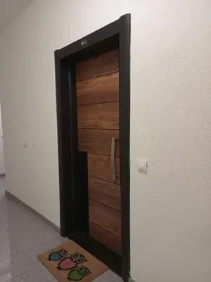 a wooden door in a room next to a refrigerator at Apartman Green wood in Arandjelovac