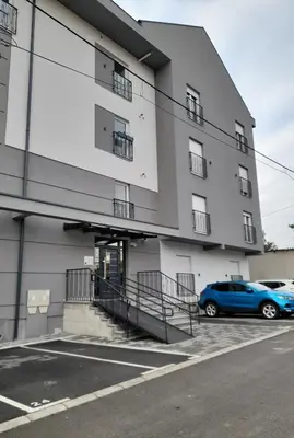 a blue car parked in front of a building at Apartman Green wood in Arandjelovac