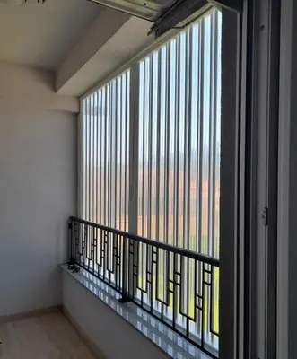 a balcony with a large window in a room at Apartman Green wood in Arandjelovac