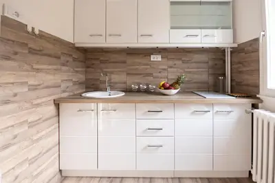 a kitchen with white cabinets and a sink at Apartman 22 in Belgrade