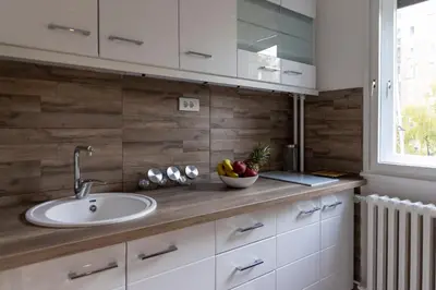 a kitchen with a sink and a bowl of fruit on a counter at Apartman 22 in Belgrade