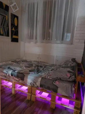 a bedroom with two beds with purple lights at Apartman 22 in Belgrade