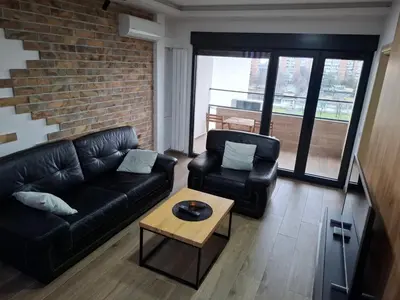 a living room with a leather couch and a coffee table at Serbian home - 44, Gandijeva 184, free parking in Bežanija