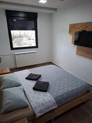 a bedroom with a bed with two towels on it at Serbian home - 44, Gandijeva 184, free parking in Bežanija