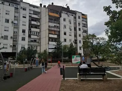 people sitting on a bench in front of a building at Serbian home - 44, Gandijeva 184, free parking in Bežanija
