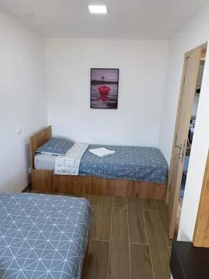 a room with two beds and a picture on the wall at Serbian home - 44, Gandijeva 184, free parking in Bežanija