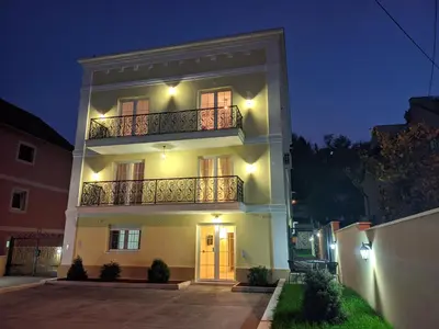 a large white building with a balcony at night at Apartmani Danube LUX Smederevo in Smederevo