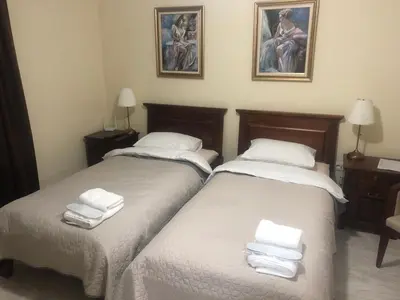 two beds in a hotel room with towels on them at Apartmani Danube LUX Smederevo in Smederevo