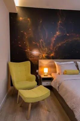 a bedroom with a bed and a yellow chair at Galaxy Apartments in Belgrade