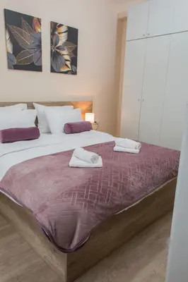 a bedroom with a bed with two towels on it at Galaxy Apartments in Belgrade
