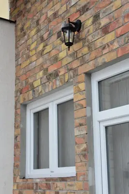 a brick wall with two windows and a light on it at Damun in Belgrade