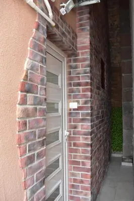 a brick wall with a door in front of it at Damun in Belgrade