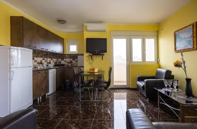 a kitchen and living room with a refrigerator and chairs at Mici Luxury Apartments in Ledine