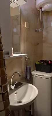 a bathroom with a sink and a toilet and a mirror at Apartment Anna in Belgrade