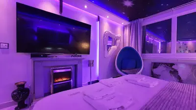 a purple room with a bed and a tv and a fireplace at Aurora Lux Spa Smart apartments in Belgrade